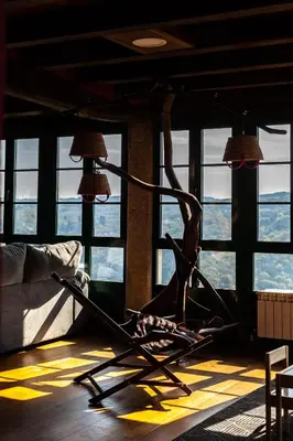 a metal chair in a room with windows at Casa Vistaboa Ribeira Sacra in Chantada