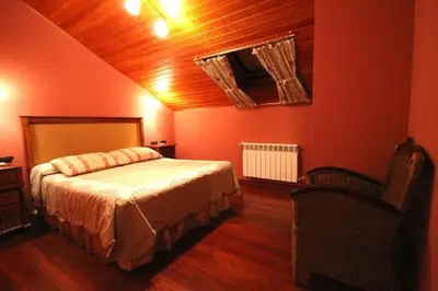 a red bedroom with a bed and a chair at Casa Suarna in Navia de Suarna