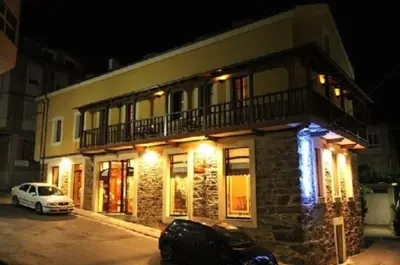 a building with a car parked in front of it at Casa Suarna in Navia de Suarna
