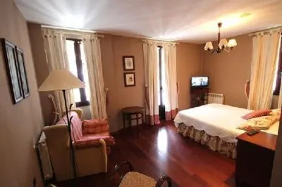 a bedroom with a bed and a table and a chair at Casa Suarna in Navia de Suarna