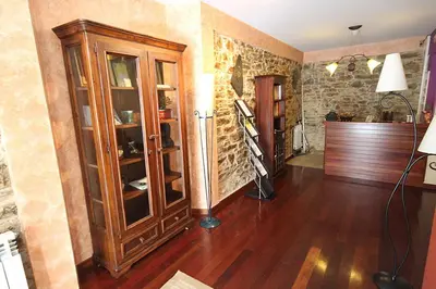 a living room with a large wooden cabinet with glass doors at Casa Suarna in Navia de Suarna