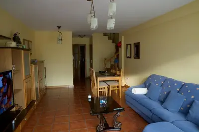 a living room with a blue couch and a table at CHALET CON PISCINA EN MIÑO-Perbes in Miño