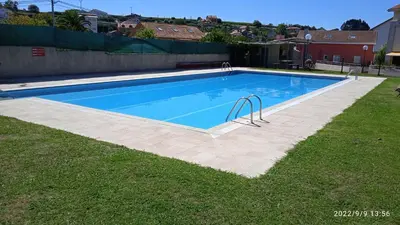 a swimming pool in a yard next to a grass field at CHALET CON PISCINA EN MIÑO-Perbes in Miño