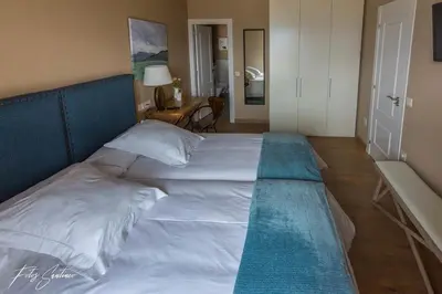 a large white bed with a blue headboard in a bedroom at Apartamentos Buenavista Tineo in Tineo