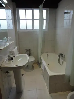 a bathroom with a sink and a tub and a toilet at Hotel Sarga in Cabañas