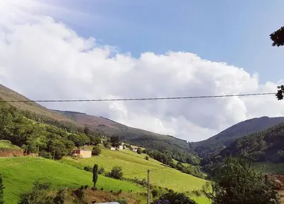 a view of a green valley with mountains at Casa de aldea Amezaga in Taramundi
