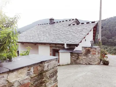 a white house with a slate roof at Casa de aldea Amezaga in Taramundi