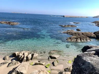 a beach with rocks and the water at La Tita in San Ciprián