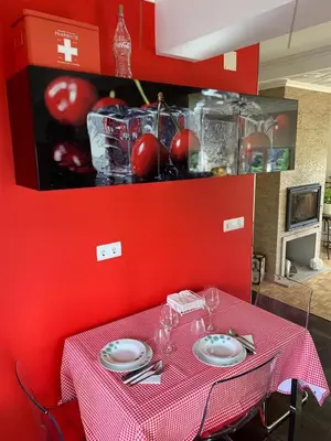 a red wall with a table with plates and glasses at La Tita in San Ciprián