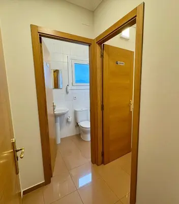 a bathroom with a toilet and a window and a door at Hotel Reigosa in Pontevedra