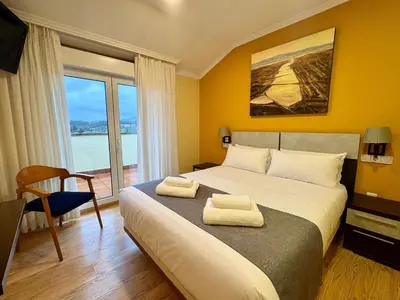 a bedroom with a large bed with two towels on it at Hotel Reigosa in Pontevedra