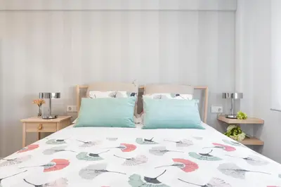 a bedroom with a bed with a floral bedspread at NC APARTMENT in Santiago de Compostela