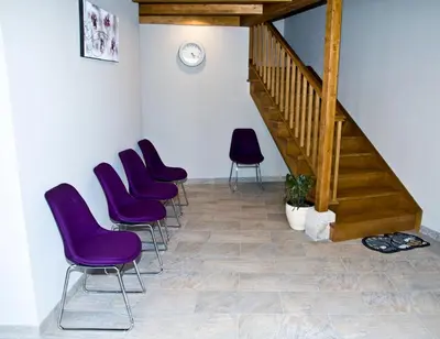a waiting room with purple chairs and a staircase at PENSION SERRANO in Sarria