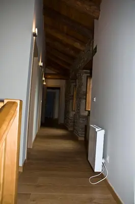a hallway in a building with a wall with a radiator at PENSION SERRANO in Sarria