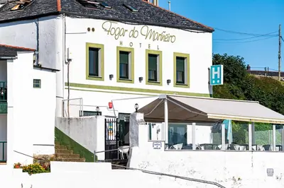 a white building with a sign for a hotel at Hotel Alda Fogar do Mariñeiro in Ribadeo