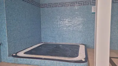 a blue tiled bathroom with a tub in a shower at Hotel Alda Fogar do Mariñeiro in Ribadeo