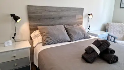 a bedroom with a bed with a wooden headboard at Soleado a un Paseo de la Catedral in Santiago de Compostela