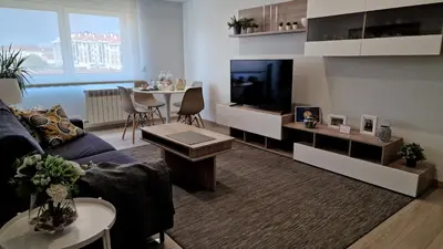 a living room with a couch and a flat screen tv at Soleado a un Paseo de la Catedral in Santiago de Compostela