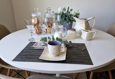 a white table with cups and vases on it at Soleado a un Paseo de la Catedral in Santiago de Compostela