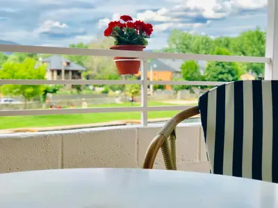 a table and a chair and a flower pot on a window at Casa de la Playa in Vega de Espinareda