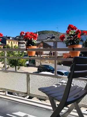 a chair on a balcony with flowers on a fence at Casa de la Playa in Vega de Espinareda