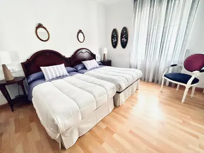 a bedroom with a large bed and a chair at Casa de la Playa in Vega de Espinareda