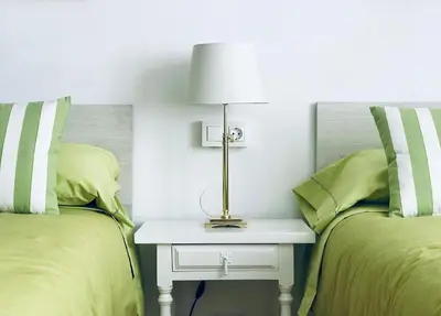 a bedroom with two beds and a table with a lamp at Casa de la Playa in Vega de Espinareda