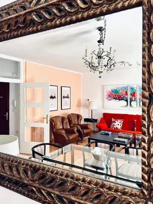 a mirror reflecting a living room with a couch and a table at Casa de la Playa in Vega de Espinareda