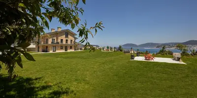 a large house on top of a grassy hill at Apartamentos Arumes do Mar e Montaña - Viveiro in Viveiro