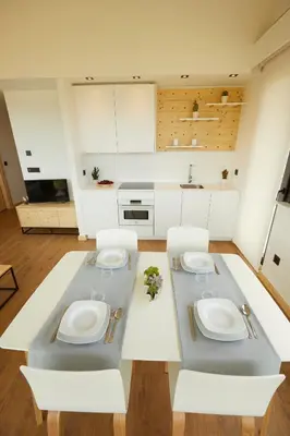 a dining room with a table and chairs and a kitchen at Apartamentos Arumes do Mar e Montaña - Viveiro in Viveiro