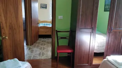 a room with a chair and a bedroom with green walls at Casa do Gaiteiro - Casa de Aldea en O Pereiro in Pereiro
