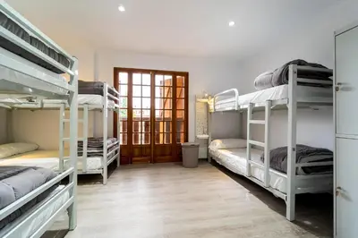 a room with three bunk beds and a hallway at Albergue Mirador de Pedrouzo in O Pedrouzo