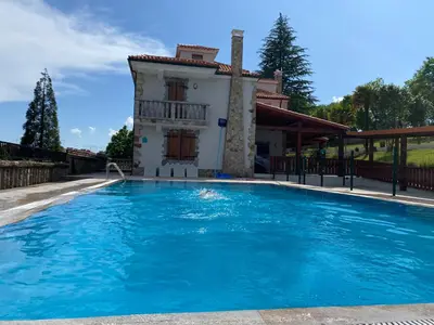 a large swimming pool in front of a house at Albergue Mirador de Pedrouzo in O Pedrouzo