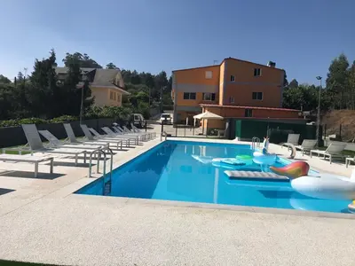 a swimming pool with lounge chairs and a swimming pool at Pensión CHE in O Pedrouzo