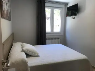 a bedroom with a bed with a window and a television at Pensión CHE in O Pedrouzo
