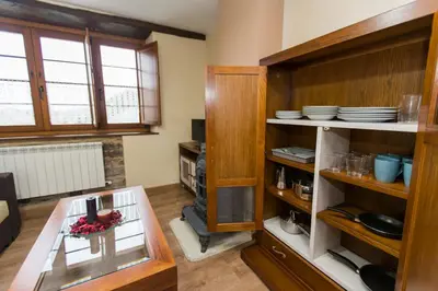 a kitchen with wooden shelves with dishes on them at Apartamentos Casa Mateo in Navia
