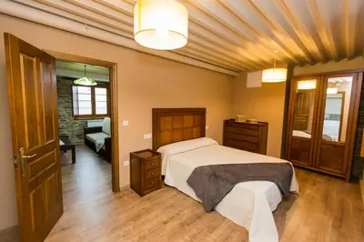 a bedroom with a large bed and a couch at Apartamentos Casa Mateo in Navia