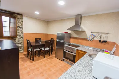 a kitchen with a table and a black refrigerator at Apartamentos Casa Mateo in Navia