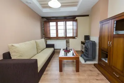 a living room with a couch and a tv at Apartamentos Casa Mateo in Navia