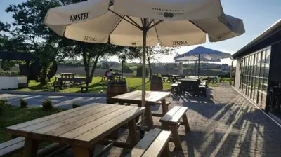 two picnic tables and an umbrella on a patio at Apartamentos Casa Mateo in Navia
