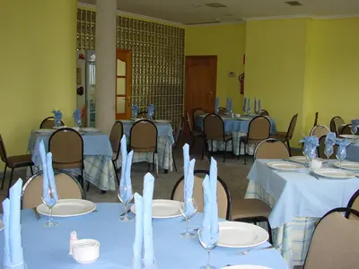 a dining room with tables and chairs with white tablecloths at Hotel La Mora in Villaseca de Laciana