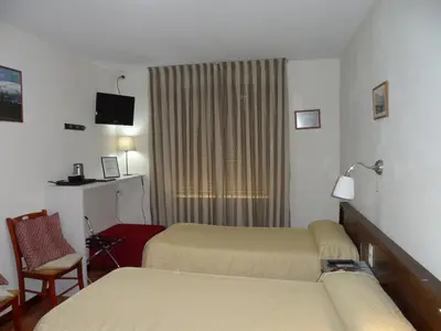 a hotel room with two beds and a window at Hostal Coruña in Astorga