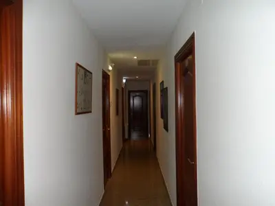 a hallway with white walls and a long hallway at Hostal Coruña in Astorga