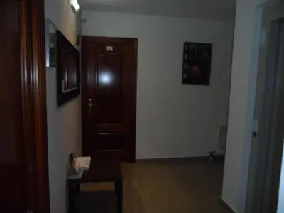 a hallway with a wooden door in a room at Hostal Coruña in Astorga