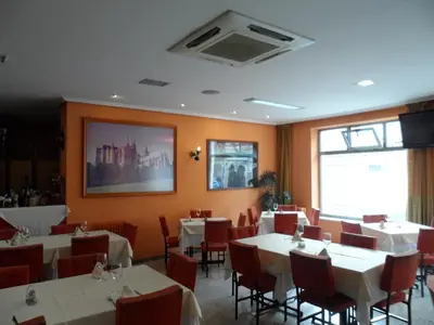 a dining room with white tables and red chairs at Hostal Coruña in Astorga