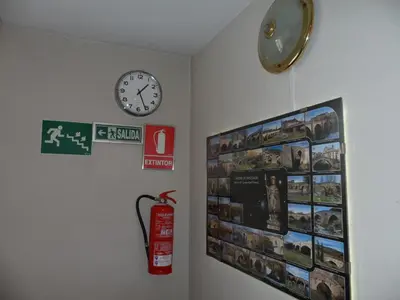 a room with a fire hydrant and a clock on a wall at Hostal Coruña in Astorga