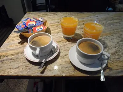 two cups of coffee on a table with two glasses of orange juice at Hostal Coruña in Astorga