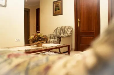 a living room with a chair and a coffee table at HOTEL LORENZO in Carballino