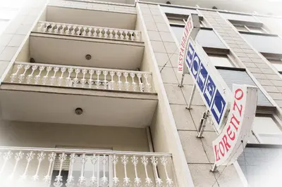 a building with a balcony and street signs on it at HOTEL LORENZO in Carballino