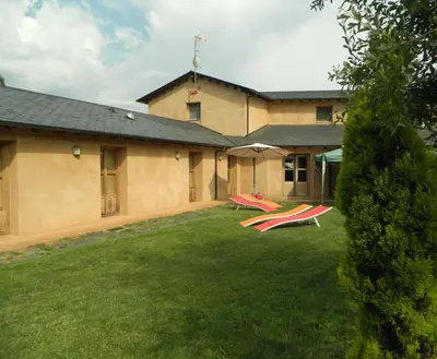 a building with two red chairs in the yard at Las Fontaninas in Noceda del Bierzo